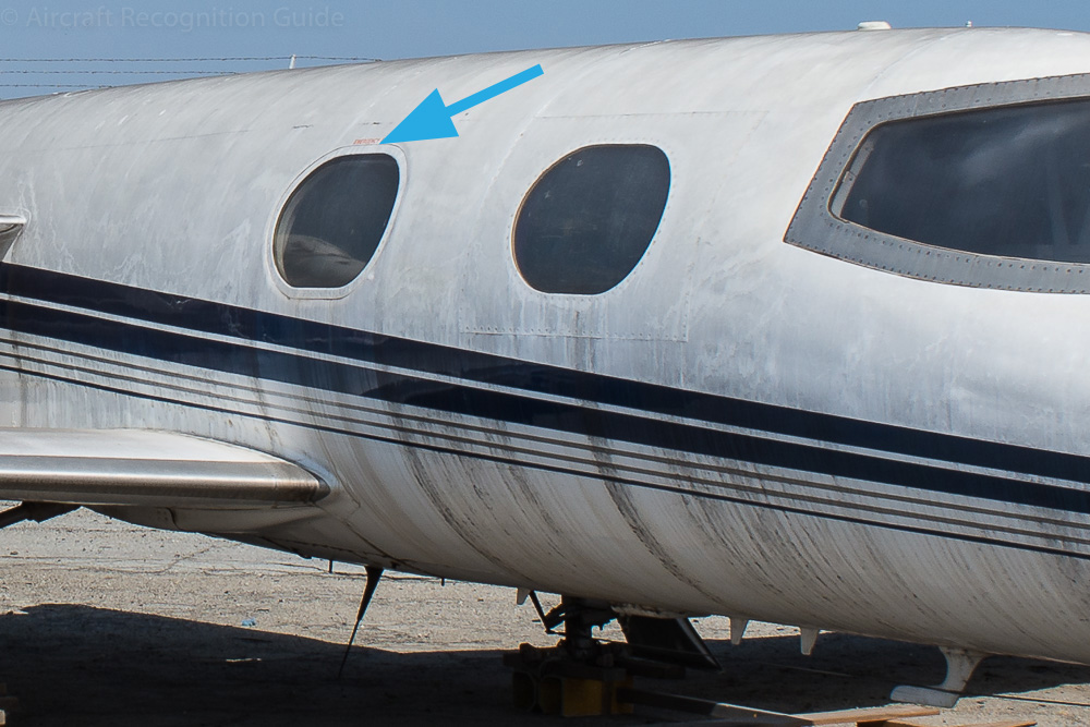 Another key feature of early model Learjets are the large cabin windows with the shape of a race track. The Learjet 23 has no visible external handle at the edge of the emergency exit in the second window. Image